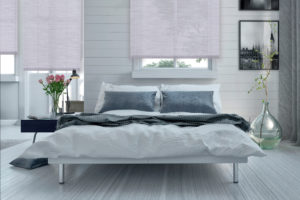 Double divan bed in a light spacious upmarket modern bedroom with large windows and artwork on the walls in grey and white decor